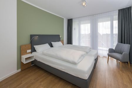 Deichhäuser Anna Küste Deichhäuser Anna Küste 6-31 Bensersiel - Schlafzimmer mit Doppelbett und Sitzgelegenheit