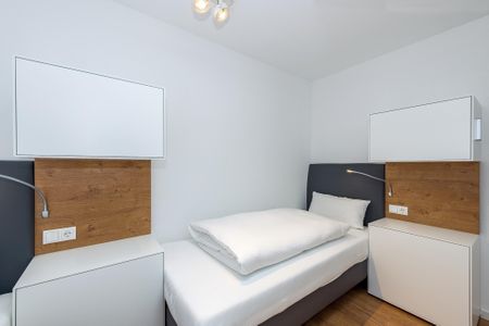Deichhäuser Anna Küste Deichhäuser Anna Küste 6-31 Bensersiel - Schlafzimmer mit zwei Einzelbetten und Nachttisch