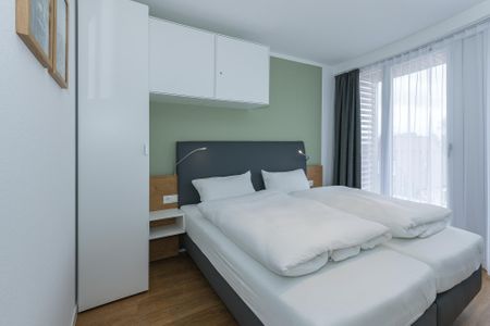 Deichhäuser Anna Küste Deichhäuser Anna Küste 6-33 Bensersiel - Schlafzimmer mit Doppelbett und Kleiderschrank sowie Zugang zum Balkon