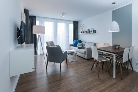 Deichhäuser Anna Küste Deichhäuser Anna Küste 6-34 Bensersiel - Wohn-Essbereich mit Couch, Esstisch, Sitzgelegenheit und Flatscreen TV