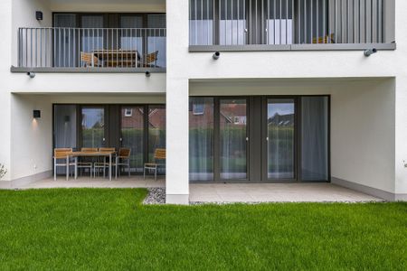 Deichhäuser Anna Küste Deichhäuser Anna Küste 7-11 Bensersiel - Überdachte Terrasse mit Sitzgelegenheit und Grünfläche