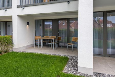 Deichhäuser Anna Küste Deichhäuser Anna Küste 7-11 Bensersiel - Überdachte Terrasse mit Sitzgelegenheit und Grünfläche