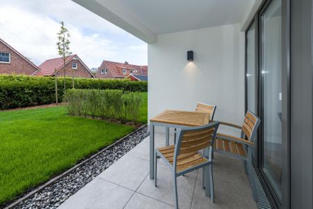 Deichhäuser Anna Küste Deichhäuser Anna Küste 7-12 Bensersiel - Überdachte Terrasse mit Sitzgelegenheit und Grünfläche