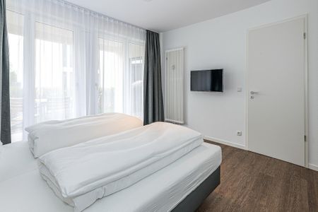Deichhäuser Anna Küste Deichhäuser Anna Küste 7-14 Bensersiel - Schlafzimmer mit Doppelbett, Flatscreen-TV und Zugang zur Terrasse