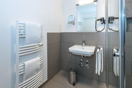 Deichhäuser Anna Küste Deichhäuser Anna Küste 7-14 Bensersiel - Badezimmer mit Dusche, Handtuchwärmer, Waschbecken und Spiegel