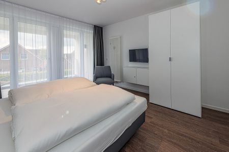 Deichhäuser Anna Küste Deichhäuser Anna Küste 7-21 Bensersiel - Schlafzimmer mit Doppelbett, Kleiderschrank, Flatscreen TV und Zugang zum Balkon