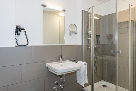 Deichhäuser Anna Küste Deichhäuser Anna Küste 7-21 Bensersiel - Badezimmer mit Dusche, Waschbecken, Föhn und Spiegel