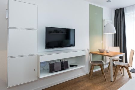 Deichhäuser Anna Küste Deichhäuser Anna Küste 7-22 Bensersiel - Wohn-Ess-Schlafbereich mit Esstisch und Flatscreen TV
