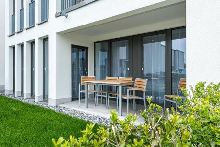 Deichhäuser Anna Küste Deichhäuser Anna Küste 8-14 Bensersiel - Überdachte Terrasse mit Sitzgelegenheit und Grünfläche