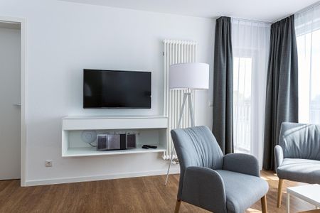 Deichhäuser Anna Küste Deichhäuser Anna Küste 8-34 Bensersiel - Wohn-Essbereich mit Couch und Flatscreen-TV