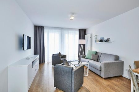 Deichhäuser Anna Küste Deichhäuser Anna Küste 4-30 Bensersiel - Wohnbereich mit Sofa, Sessel, Couchtisch und Zugang zum Balkon