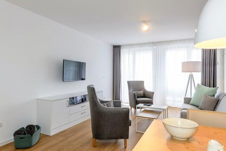 Deichhäuser Anna Küste Deichhäuser Anna Küste 1-30 Bensersiel - Wohn/Essbereich mit Couch, Sesseln und TV