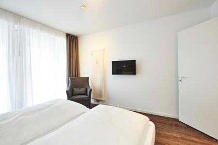 Deichhäuser Anna Küste Deichhäuser Anna Küste 2-11 Bensersiel - Schlafzimmer mit Doppelbett, Sessel und TV