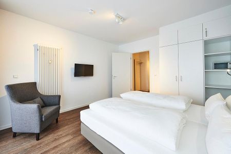 Deichhäuser Anna Küste Deichhäuser Anna Küste 2-11 Bensersiel - Schlafzimmer mit Doppelbett, Sessel und Kleiderschrank