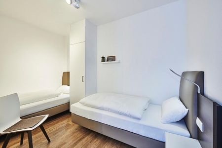 Deichhäuser Anna Küste Deichhäuser Anna Küste 2-11 Bensersiel - Schlafzimmer mit zwei Einzelbetten, Kleiderschrank und Stuhl