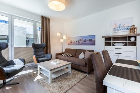 Aparthotel Ostseeallee Aparthotel Ostseeallee 2-12 Boltenhagen - Wohn-/Essbereich mit Doppelschlafcouch, Couchtisch, Sessel, Esstisch, Sitzgelegenheiten