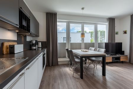 Aparthotel Ostseeallee Aparthotel Ostseeallee 2-17 Boltenhagen - Wohn-/Essbereich mit Küchenzeile, Esstisch und Sitzgelegenheiten