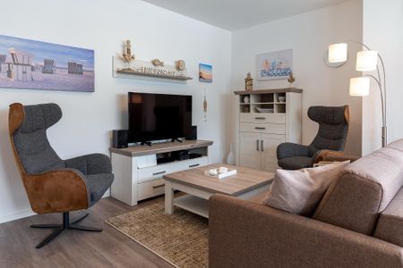 Aparthotel Ostseeallee Aparthotel Ostseeallee 2-18 Boltenhagen - Wohn-/Essbereich mit Doppelschlafcouch, Couchtisch, Sessel und TV