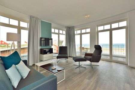 Aparthotel Anna Düne Aparthotel Anna Düne 1-18 Wangerooge - Wohn/ Essbereich mit Couch, zwei Sessel und Fernseher
