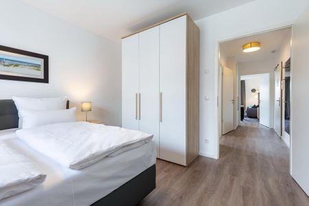 Aparthotel Ostseeallee Aparthotel Ostseeallee 3-23 Boltenhagen - Schlafzimmer mit Boxspringbett, Kleiderschrank und Blick zum Wohn-/Essbereich