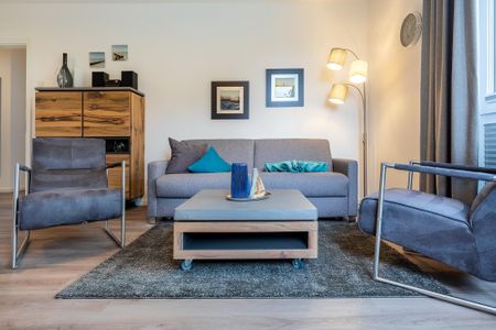 Aparthotel Ostseeallee Aparthotel Ostseeallee 3-24 Boltenhagen - Wohn-/Essbereich mit Doppelschlafcouch, Couchtisch und Sessel