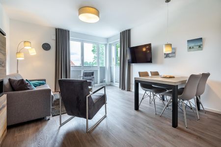 Aparthotel Ostseeallee Aparthotel Ostseeallee 3-24 Boltenhagen - Wohn-/Essbereich mit Doppelschlafcouch, TV, Esstisch und Sitzgelegenheiten