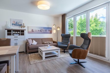 Aparthotel Ostseeallee Aparthotel Ostseeallee 3-25 Boltenhagen - Wohn-/Essbereich mit Doppelschlafcouch, Couchtisch und Sessel