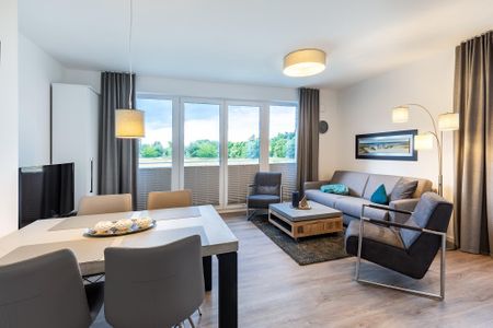 Aparthotel Ostseeallee Aparthotel Ostseeallee 3-26 Boltenhagen - Wohn-/Essbereich mit Doppelschlafcouch, Couchtisch, Sitzgelegenheiten und TV