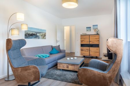 Aparthotel Ostseeallee Aparthotel Ostseeallee 3-27 Boltenhagen - Wohn-/Essbereich mit Doppelschlafcouch, Couchtisch und Sessel