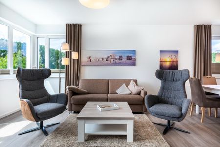 Aparthotel Ostseeallee Aparthotel Ostseeallee 3-28 Boltenhagen - Wohn-/Essbereich mit Doppelschlafcouch, Couchtisch und Sessel