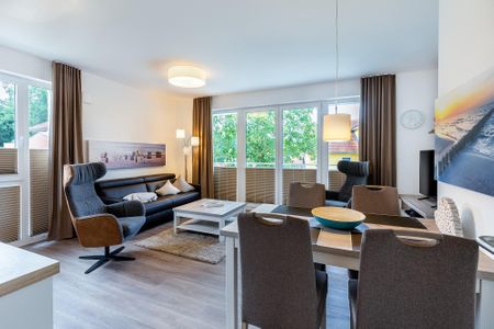 Aparthotel Ostseeallee Aparthotel Ostseeallee 4-33 Boltenhagen - Wohn-/Essbereich mit Doppelschlafcouch, Couchtisch, Esstisch und Sitzgelegenheiten