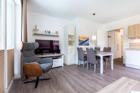 Aparthotel Ostseeallee Aparthotel Ostseeallee 4-33 Boltenhagen - Wohn-/Essbereich mit Tisch, Sitzgelegenheiten und TV