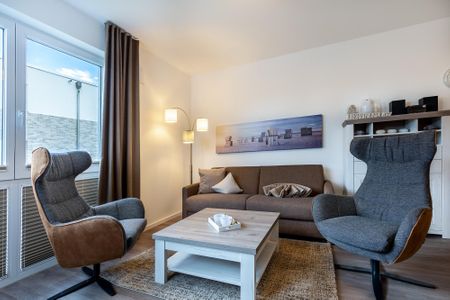Aparthotel Ostseeallee Aparthotel Ostseeallee 4-35 Boltenhagen - Wohn-/Essbereich mit Doppelschlafcouch, Couchtisch und Sessel