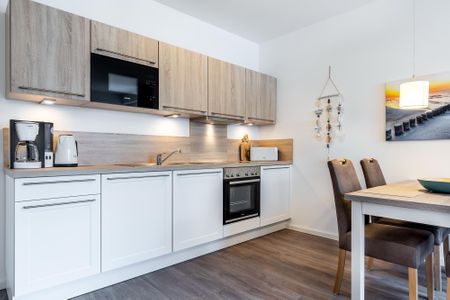 Aparthotel Ostseeallee Aparthotel Ostseeallee 4-35 Boltenhagen - Wohn-/Essbereich mit Esstisch und Küchenzeile