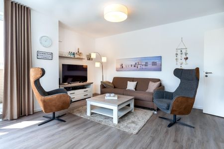 Aparthotel Ostseeallee Aparthotel Ostseeallee 4-37 Boltenhagen - Wohn-/Essbereich mit Doppelschlafcouch, Couchtisch, Sessel und TV