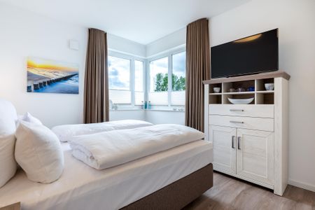 Aparthotel Ostseeallee Aparthotel Ostseeallee 4-38 Boltenhagen - Schlafzimmer mit Boxspringbett (1,80 x 2,00 m), Kommode und TV