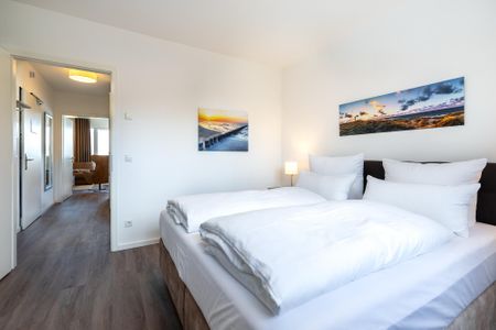 Aparthotel Ostseeallee Aparthotel Ostseeallee 4-39 Boltenhagen - Schlafzimmer mit Boxspringbett und Blick auf den Wohn-/Essbereich