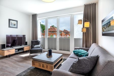 Aparthotel Ostseeallee Aparthotel Ostseeallee 5-43 Boltenhagen - Wohn-/Essbereich mit Doppelschlafcouch, Couchtisch, TV und Zugang zum Balkon