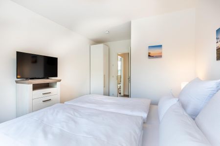 Aparthotel Ostseeallee Aparthotel Ostseeallee 5-46 Boltenhagen - Schlafzimmer "1" mit Boxspringbett, TV und Blick zum Flur