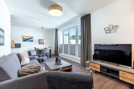 Aparthotel Ostseeallee Aparthotel Ostseeallee 5-47 Boltenhagen - Wohn-/Essbereich mit Doppelschlafcouch, Couchtisch, Esstisch, Sitzgelegenheiten und Zugang zur Dachterrasse