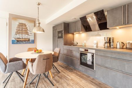Haus Stubnitz Binz-Prora Haus Stubnitz "Meerzeit" 2.4 Rügen - Wohn-Essbereich mit Esstisch, Sitzgelegenheit und Küchenzeile