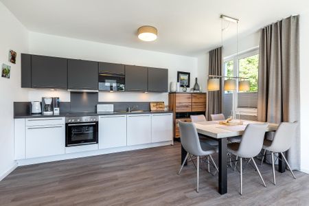 Aparthotel Ostseeallee Aparthotel Ostseeallee 5-43 Boltenhagen - Wohn-/Essbereich mit Küchenzeile, Esstisch und Sitzgelegenheiten