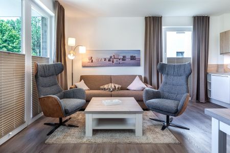 Aparthotel Ostseeallee Aparthotel Ostseeallee 2-11 Boltenhagen - Wohn-/Essbereich mit Doppelschlafcouch und Sessel