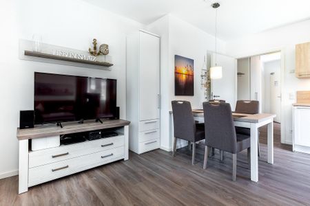 Aparthotel Ostseeallee Aparthotel Ostseeallee 4-29 Boltenhagen - Wohn-/Essbereich mit TV, Esstisch und Sitzgelegenheiten