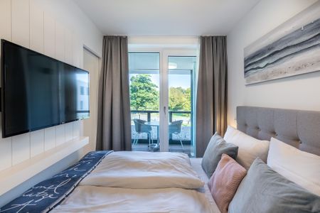 Godewindpark Travemünde Godewindpark Travemünde 1-10 Travemünde - Schlafzimmer mit Flatscreen-TV und Blick zur Loggia