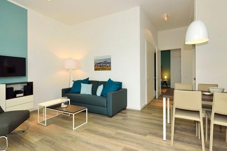 Aparthotel Anna Düne Aparthotel Anna Düne 0-08 Wangerooge - Wohn/ Essbereich mit Couch, Fernseher und Esstisch