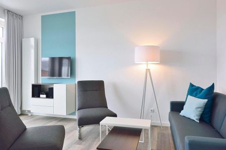 Aparthotel Anna Düne Aparthotel Anna Düne 1-13 Wangerooge - Wohn/ Essbereich mit Couch, zwei Sessel und Fernseher
