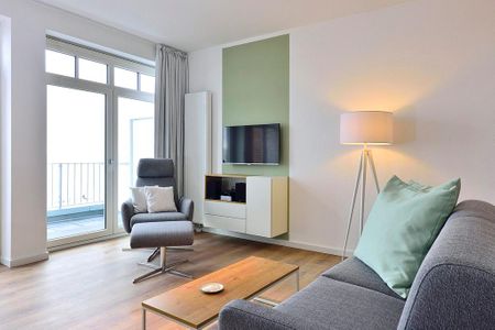 Aparthotel Anna Düne Aparthotel Anna Düne 1-20 Wangerooge - Wohn/ Essbereich mit Couch, Sessel und Fernseher