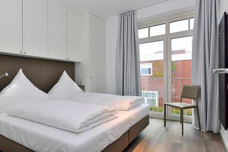 Aparthotel Anna Düne Aparthotel Anna Düne 1-24 Wangerooge - Schlafzimmer mit Doppelbett und Sitzgelegenheit