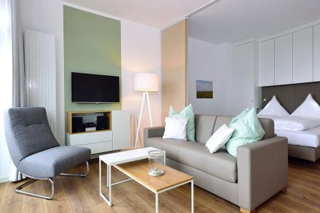 Aparthotel Anna Düne Aparthotel Anna Düne 2-28 Wangerooge - Wohn/ Essbereich mit Couch, Tisch und Fernseher
